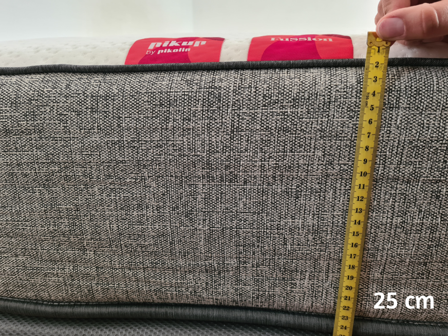 Imagem de uma trena medindo a altura do colchão.